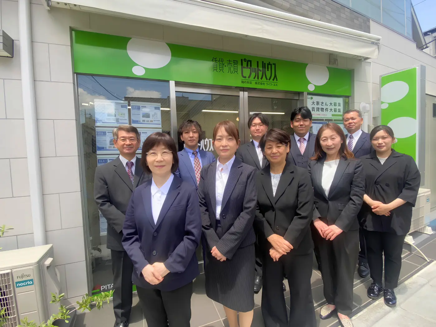 株式会社ライフ・エスのスタッフ集合写真（店舗前にて）